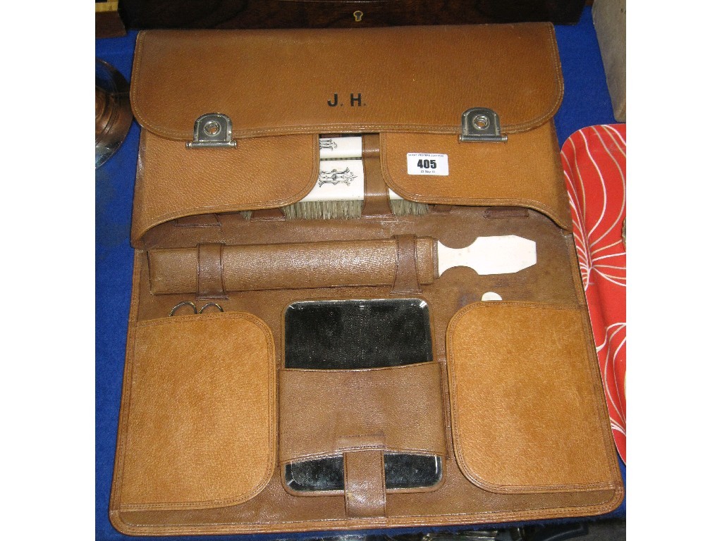 Appraisal: Leather travel toilet case fitted with silver topped jars and