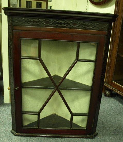 Appraisal: An Edwardian mahogany corner cabinet the glazed door enclosing shelves