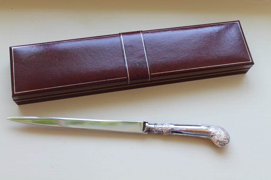 Appraisal: A modern paper knife with silver leaf capped pistol handle