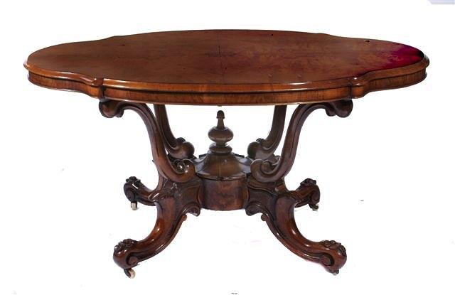 Appraisal: A VICTORIAN WALNUT SHAPED CENTRE TABLE with carved scroll supports