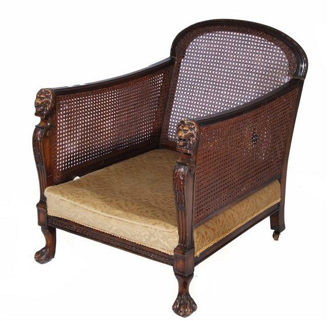 Appraisal: AN EDWARDIAN WALNUT BERGERE ARMCHAIR with carved lion mask arms