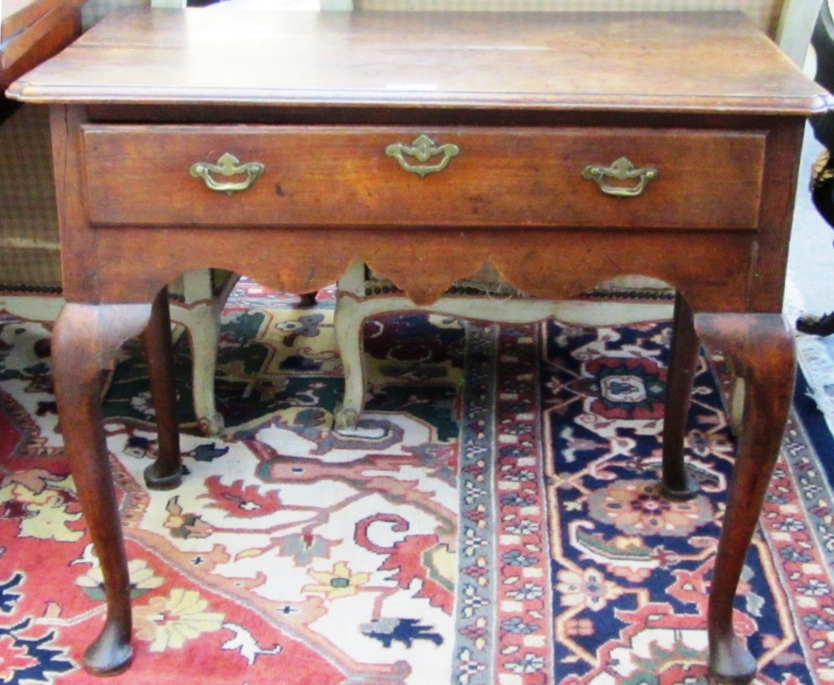 Appraisal: An th century fruitwood single drawer lowboy on cabriole supports