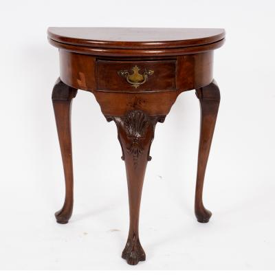 Appraisal: A walnut semi-circular fold-over top tea table in George I