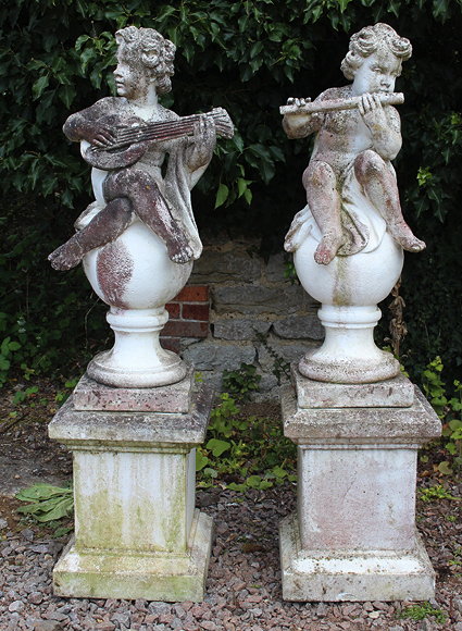 Appraisal: A PAIR OF CONCRETE SCULPTURES DEPICTING PUTTI RESTING ON BALL