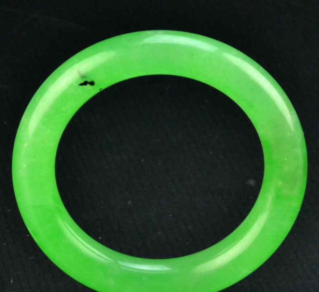 Appraisal: A Fine Chinese Carved Jadeite Bangle BraceletOf traditional tubular form