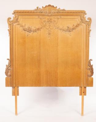 Appraisal: A carved oak headboard the gadrooned crest rail centred by