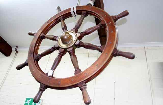 Appraisal: A LARGE TEAK AND BRASS MOUNTED SHIPS WHEEL with eight