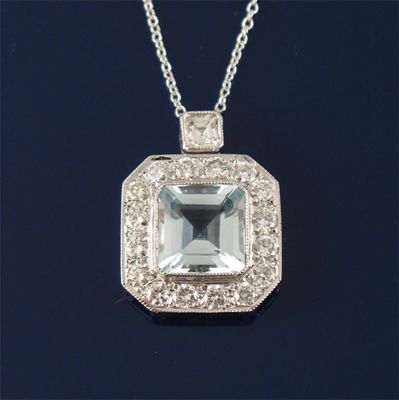 Appraisal: An aquamarine and diamond cluster pendant The square shaped aquamarine