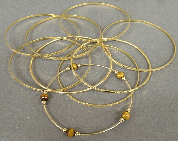 Appraisal: - Nine tested gold narrow bangle bracelets one with tiger-eye