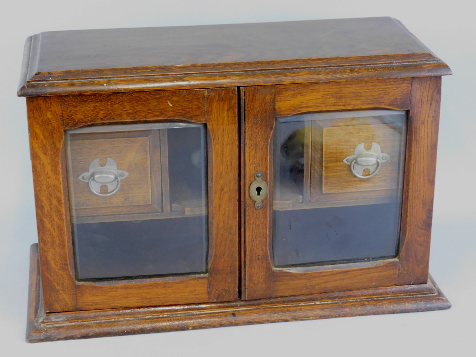 Appraisal: An Edwardian oak smoker's cabinet with two drawers enclosed by