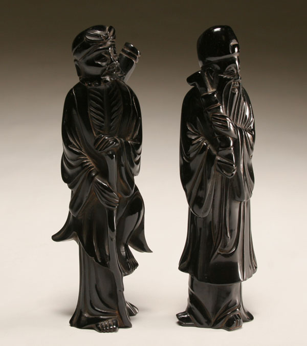 Appraisal: Pair of dark red amber carved scholar figures H