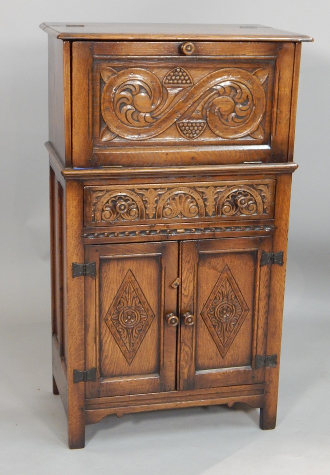 Appraisal: A Titchmarsh and Goodwin carved oak cocktail cabinet the fall