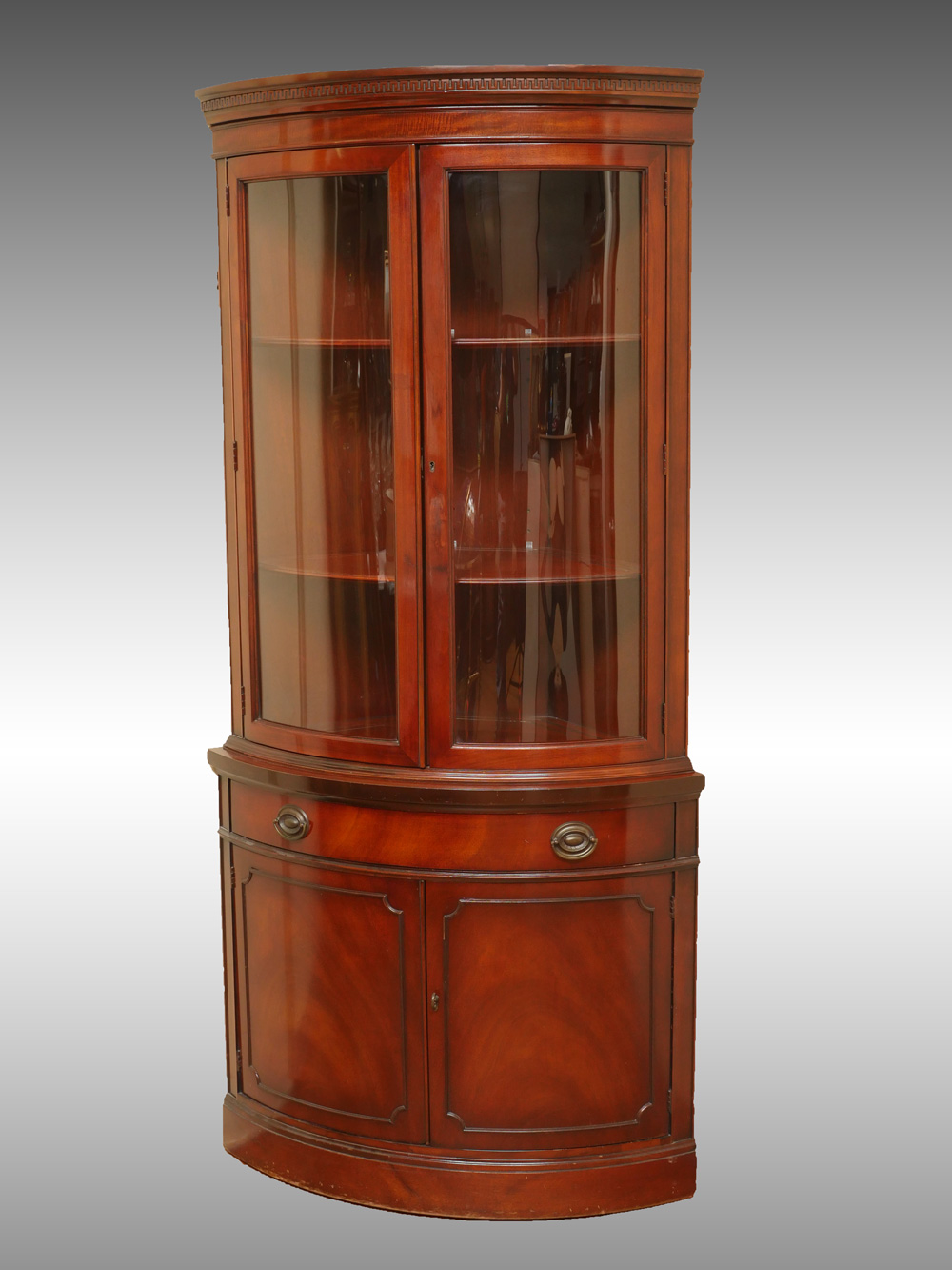 Appraisal: BOWFRONT MAHOGANY CORNER CABINET Mahogany bowfront corner cabinet having a