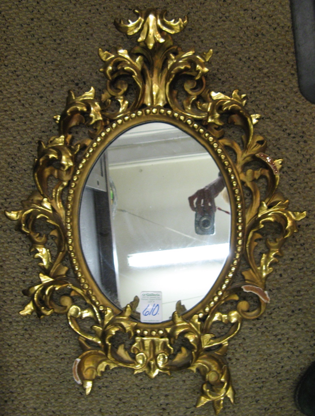 Appraisal: A BAROQUE OVOID WALL MIRROR having a gold leaf hand