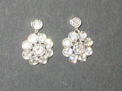 Appraisal: A PAIR OF DIAMOND EARRINGS modelled as flower heads with