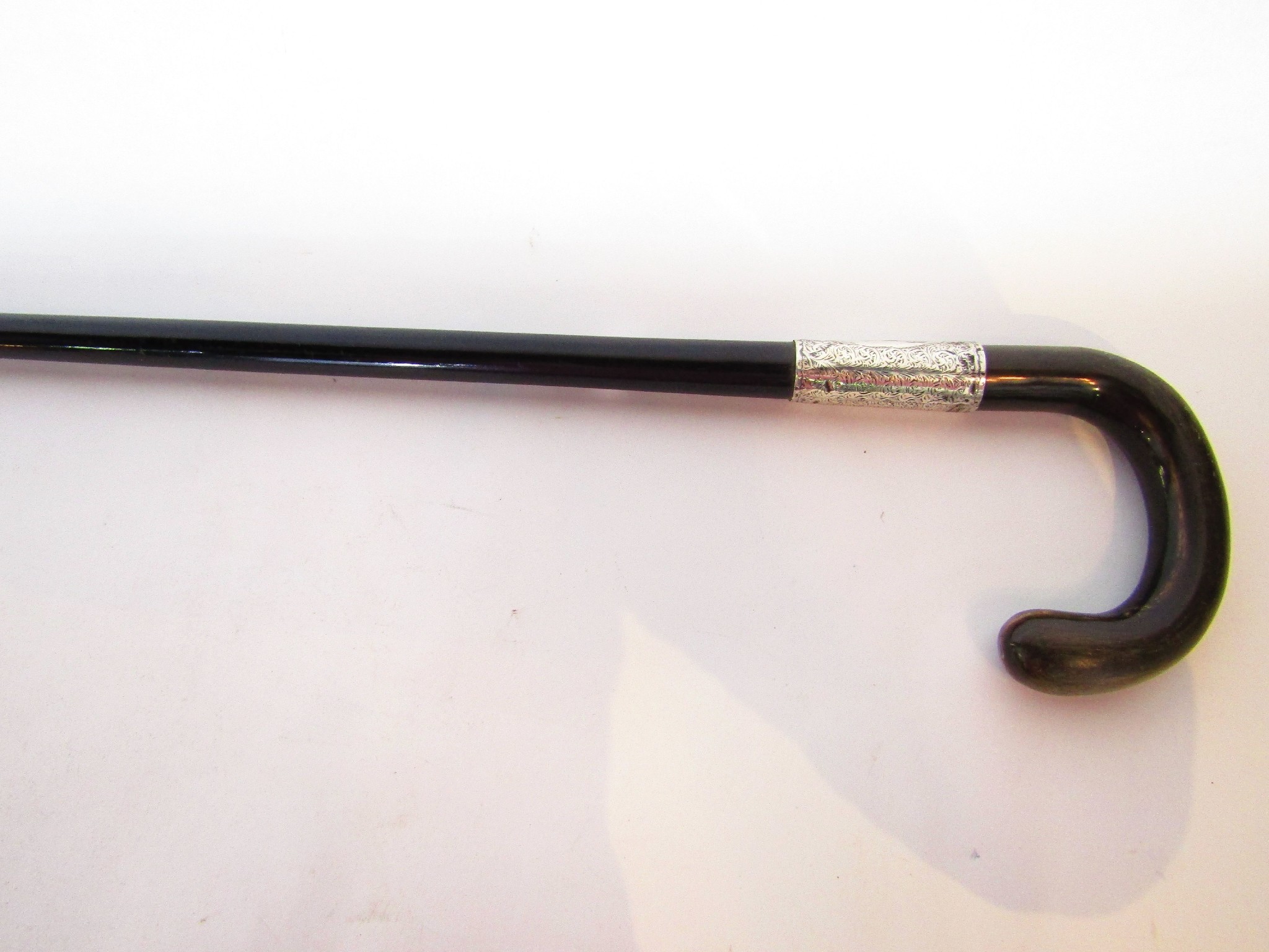 Appraisal: An ebonised tapering walking cane with crooked horn handle and