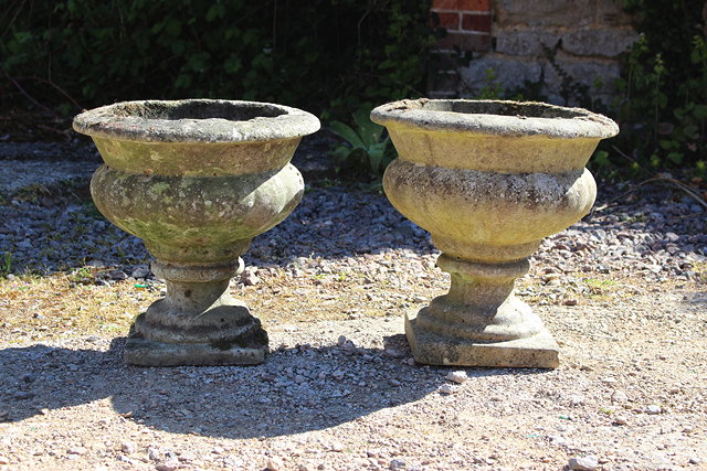 Appraisal: A PAIR OF RECONSTITUTED STONE GARDEN URNS with lobed sides