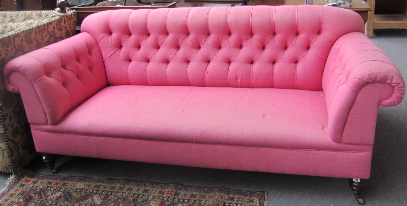 Appraisal: A Victorian button back sofa with roll-over arms on turned