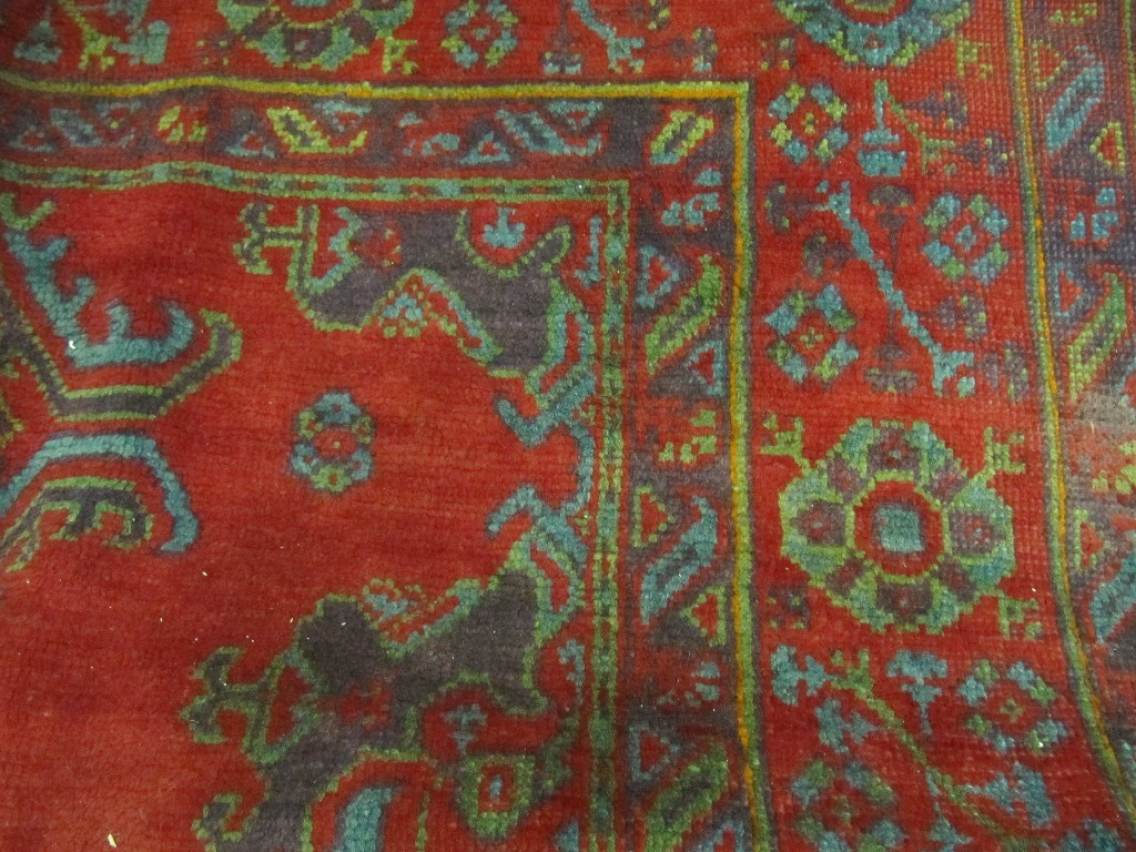 Appraisal: A large Turkish carpet decorated with multicoloured geometric designs on