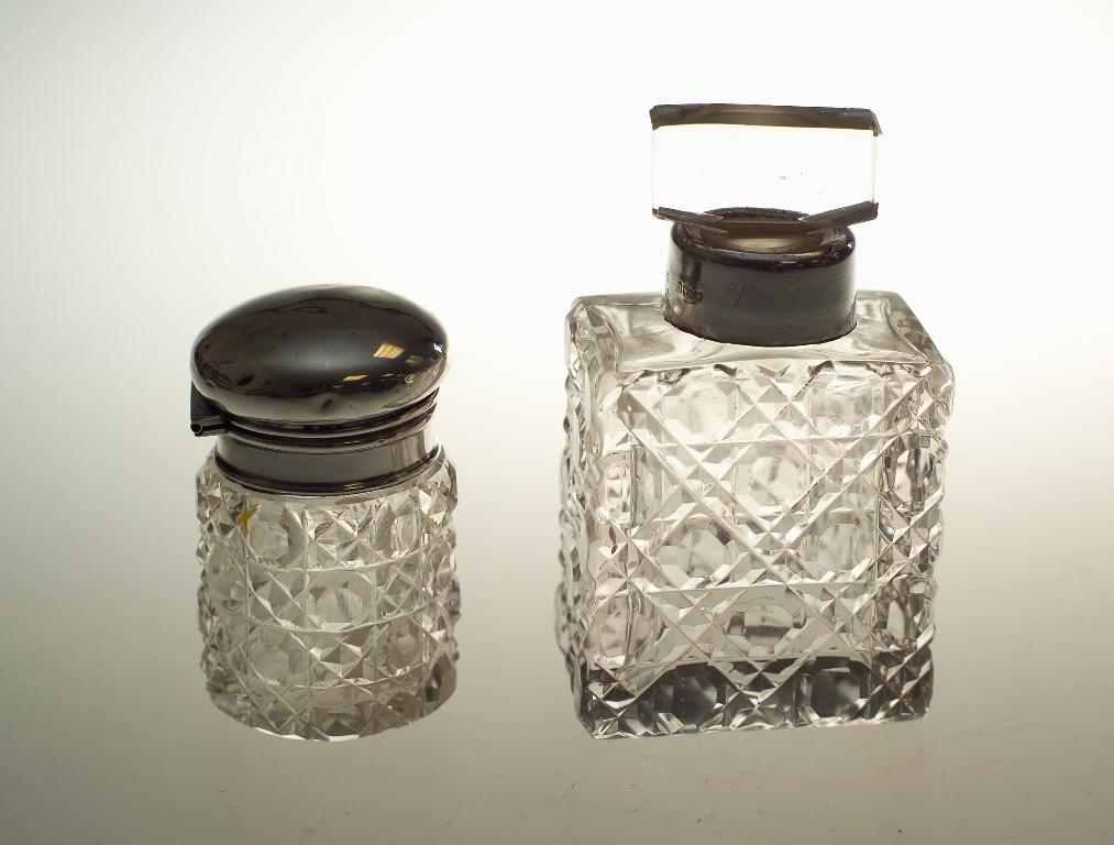 Appraisal: TWO SILVER-MOUNTED CUT-GLASS SCENT BOTTLES the first Edwardian of rectangular