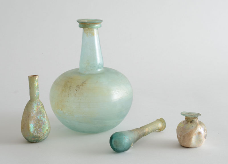 Appraisal: FOUR ANCIENT ROMAN GLASS VESSELS Comprising a carafe with spherical