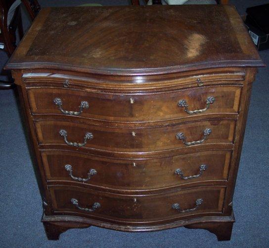 Appraisal: A mahogany serpentine front chest fitted a brushing slide and