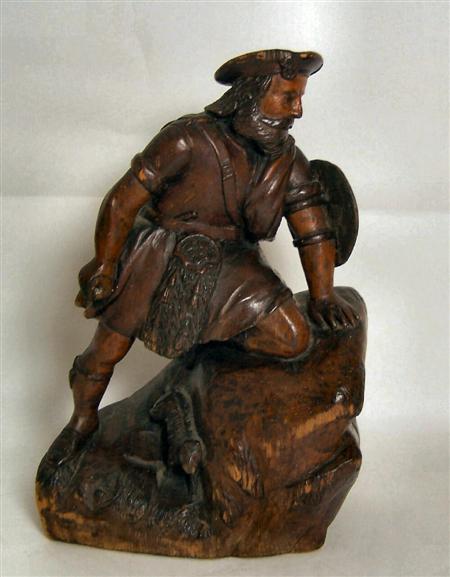 Appraisal: A th century rustic carved and stained pine figure of