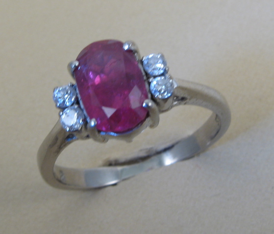 Appraisal: RUBY AND FOURTEEN KARAT WHITE GOLD RING centering an oval-cut