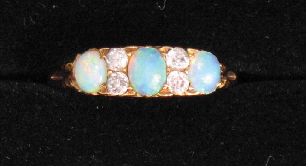 Appraisal: A DIAMOND AND OPAL DRESS RING the three graduated oval