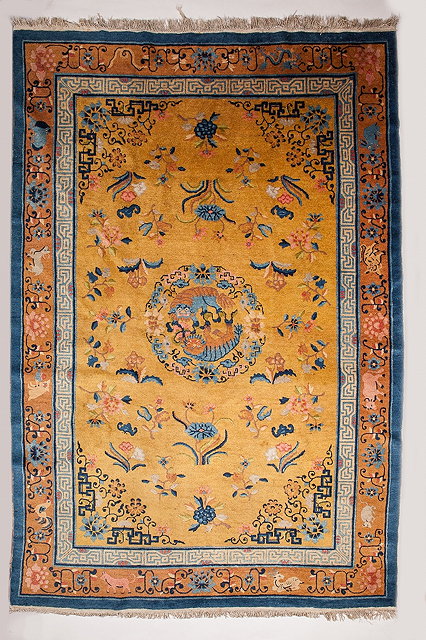 Appraisal: A CHINESE MUSTARD GROUND CARPET decorated with Foo Dogs within