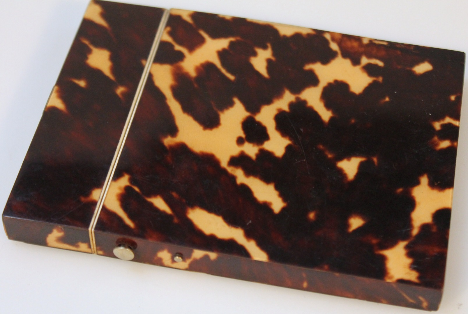 Appraisal: A thC tortoiseshell card case the hinged lid revealing a