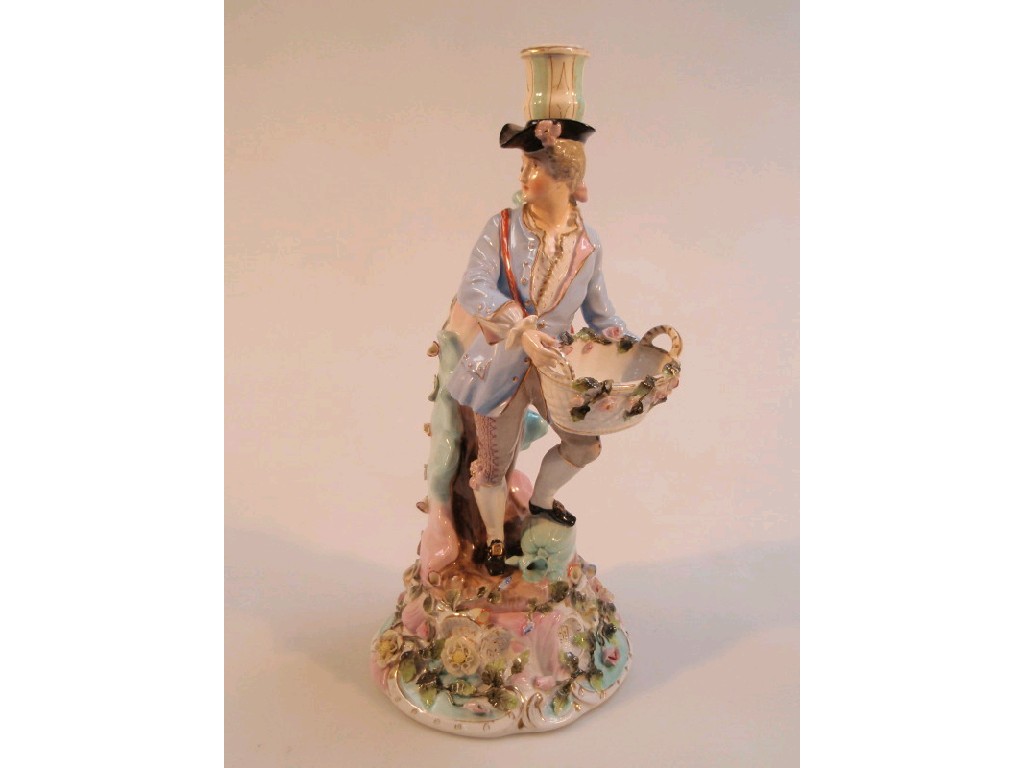 Appraisal: A German porcelain candle stand modelled as a young man