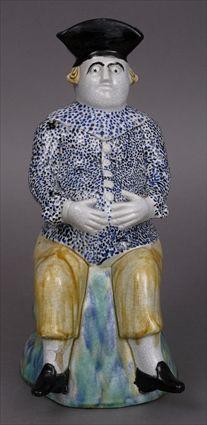 Appraisal: STAFFORDSHIRE TOBY JUG Modeled as a seated pot-bellied man wearing