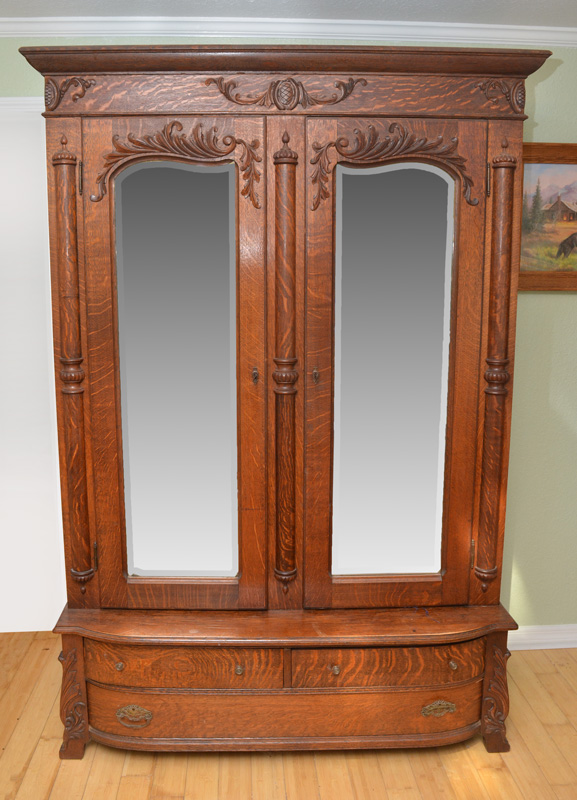 Appraisal: CARVED GOLDEN OAK ARMOIRE Pediment with applied carved foliate decoration