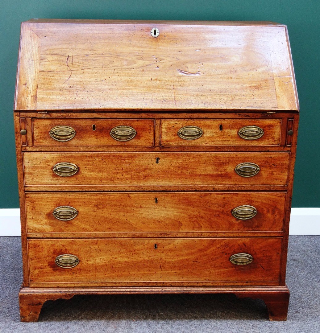 Appraisal: A George III mahogany bureau the fall enclosing a fitted