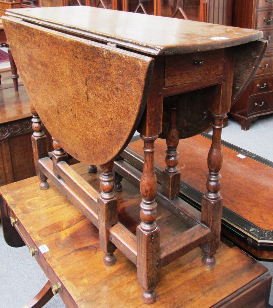 Appraisal: A George III oak small dropflap table the twin oval