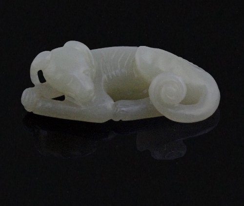 Appraisal: A Chinese celadon jade pebble carving of a recumbent hound