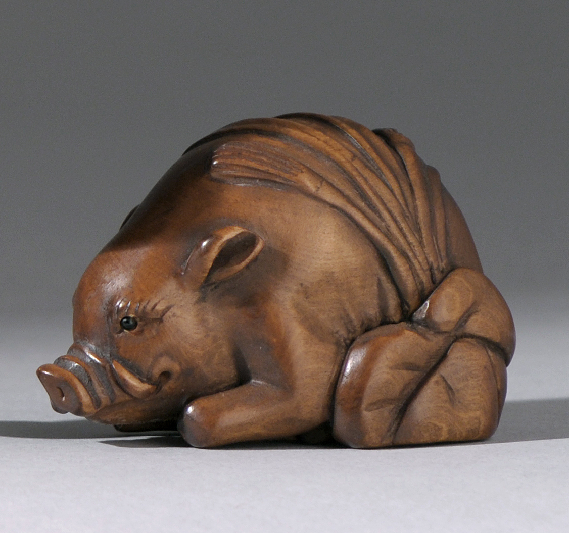 Appraisal: CARVED WOOD NETSUKE Meiji PeriodDepicting a resting boar Signed Length