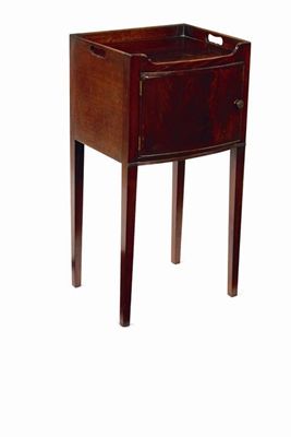 Appraisal: A George III mahogany bowfront bedside cupboard with pierced handgrips