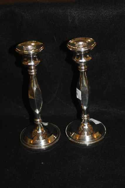 Appraisal: A PAIR OF SILVER CANDLESTICKS with stylised tapering stems and