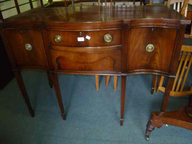 Appraisal: A REPRODUCTION MAHOGANY GEORGIAN STYLE SIDEBOARD with shaped front fitted