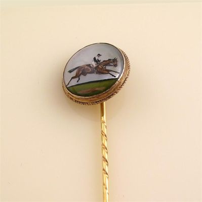 Appraisal: A gold stick pin with circular reverse carved crystal depicting