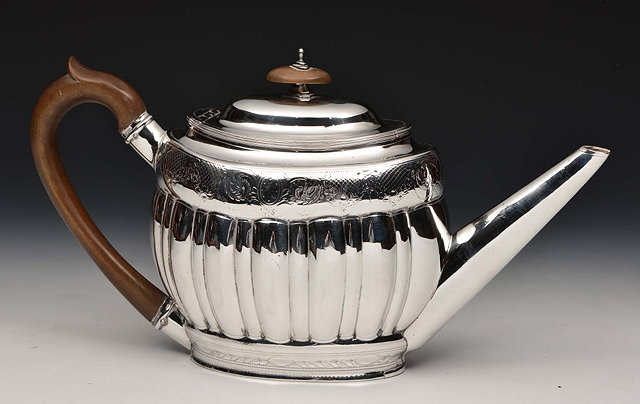 Appraisal: A GEORGIAN SILVER TEAPOT of oval form with fluted body