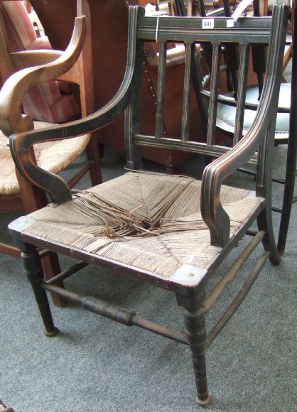 Appraisal: A late th century ebonised open armchair with rush seat