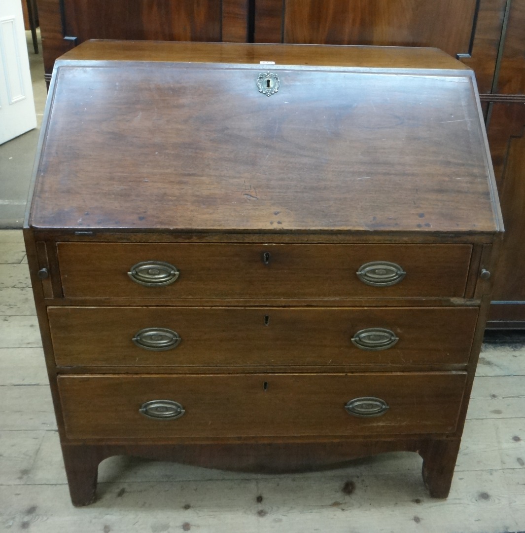 Appraisal: A George III mahogany bureau the hinged fall enclosing a