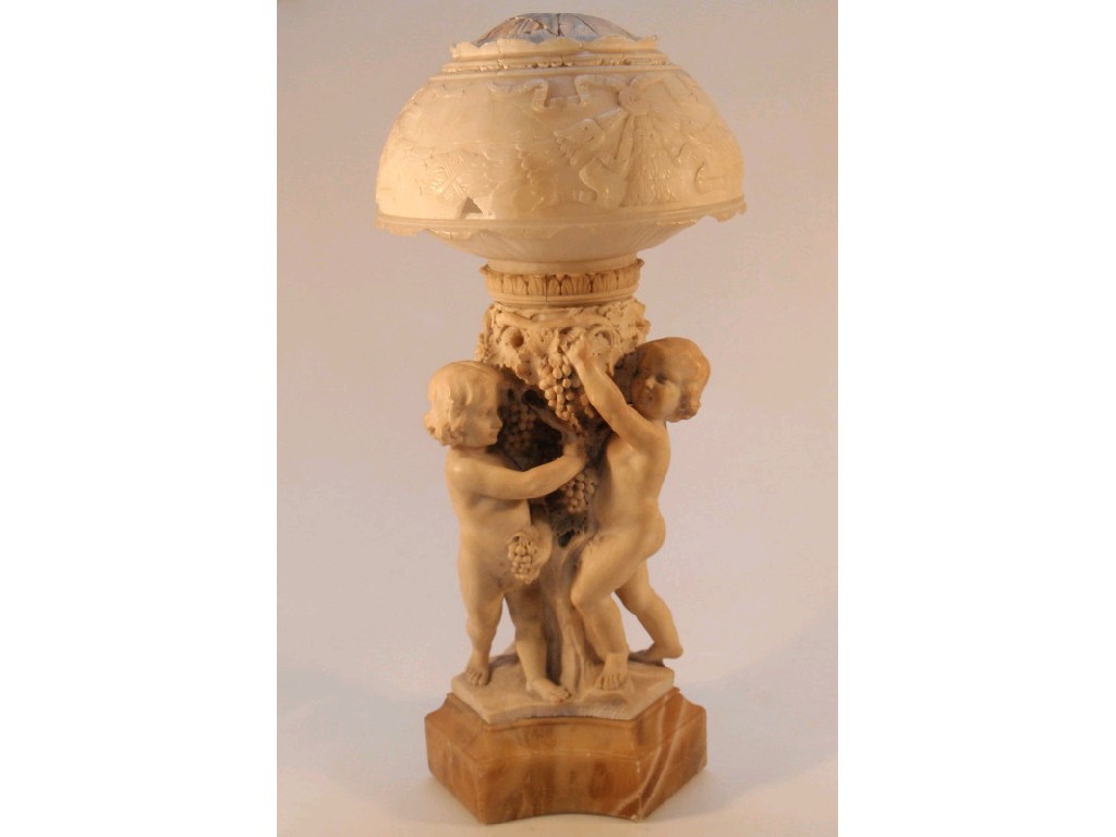 Appraisal: A finely carved alabaster table lamp formed with three bacchanalian