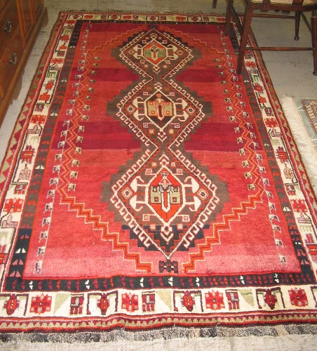 Appraisal: PERSIAN SHIRAZ CARPET the plain red field centering a column