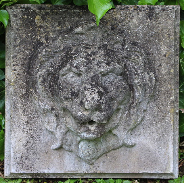 Appraisal: A SMALL WEATHERED CAST STONE LION MASK FOUNTAIN on a