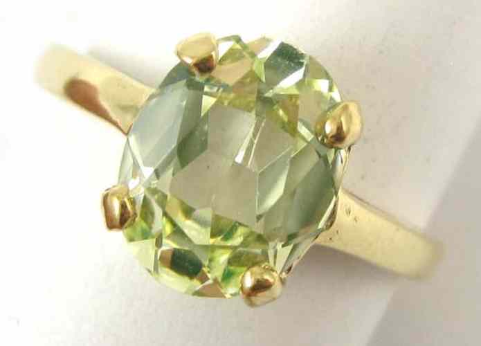 Appraisal: GROSSULARITE AND TEN KARAT GOLD RING set with an oval-cut