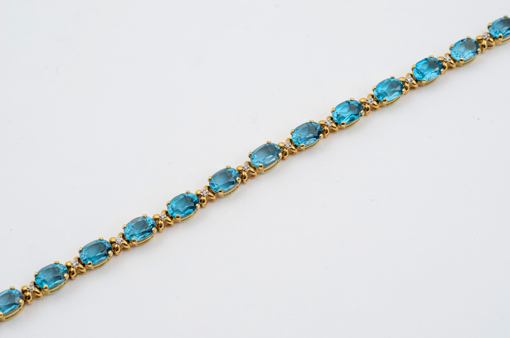 Appraisal: BLUE TOPAZ DIAMOND BRACELET K yellow gold line bracelet of